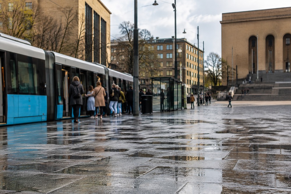 A blue Gothenburg tram at a stop on Avenyn with passengers boarding