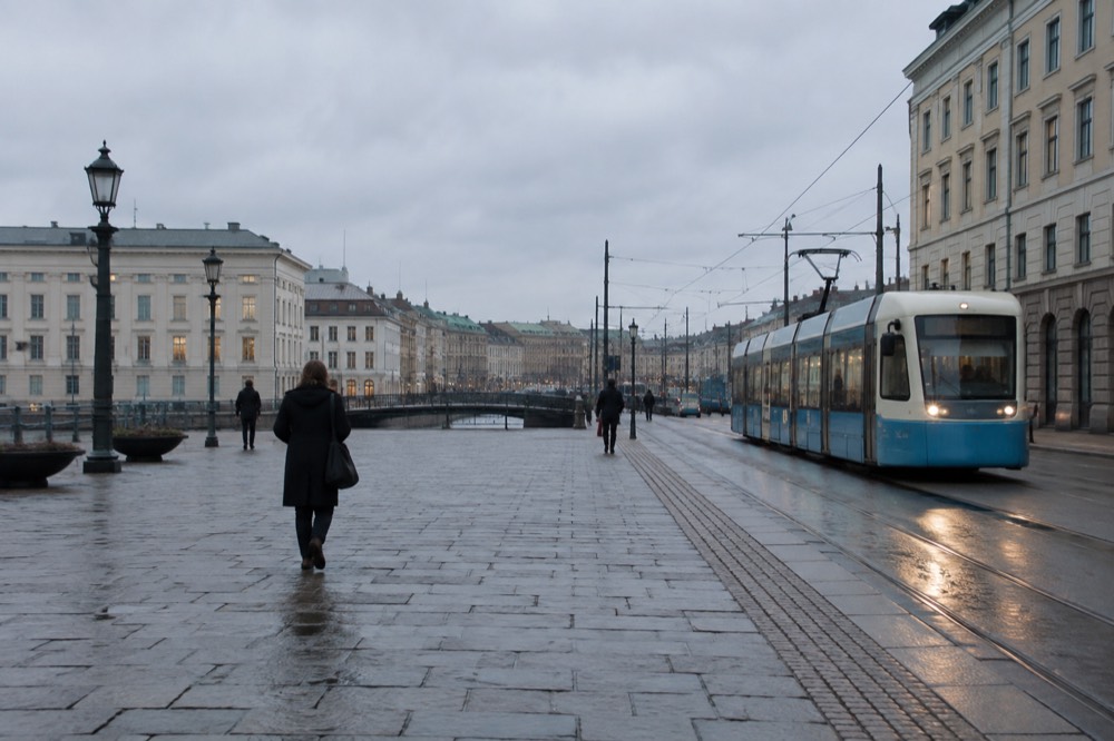 A tram on a Gothenburg street heading west toward the coast under overhead wires