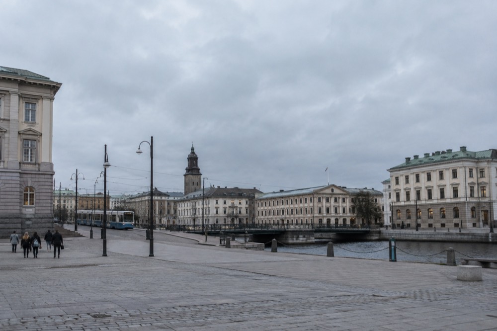 A Swedish intercity train waiting at a platform beside Gothenburg's stone station building