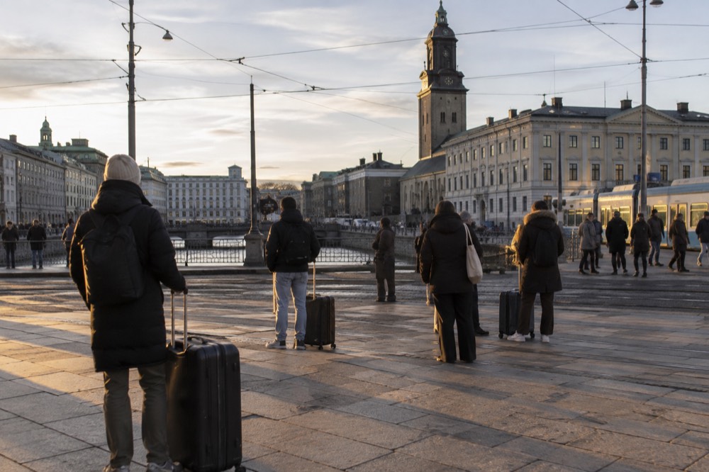 Passengers waiting with luggage in the main hall of Gothenburg Centralstation in Sweden