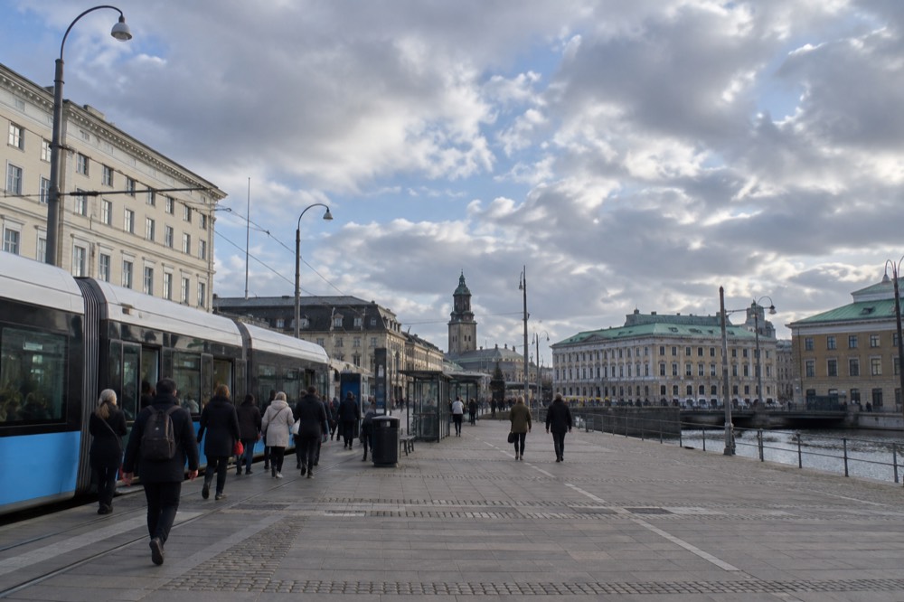 Trams and pedestrians at a stop near Göteborg Centralstation in central Gothenburg