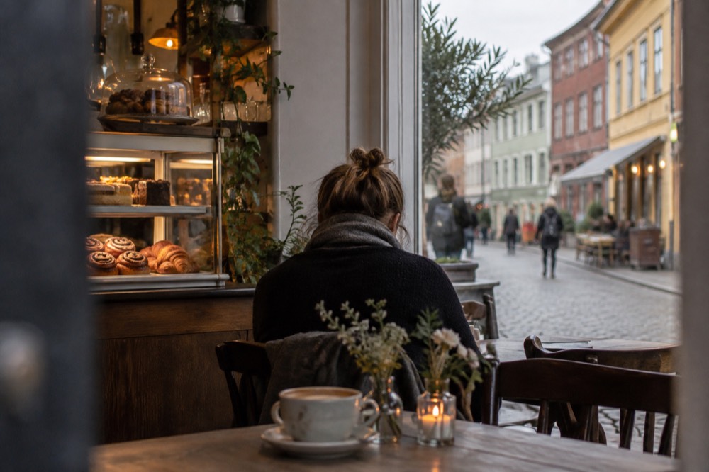 Café interior in the Haga district of Gothenburg with wooden tables and shelves of pastries