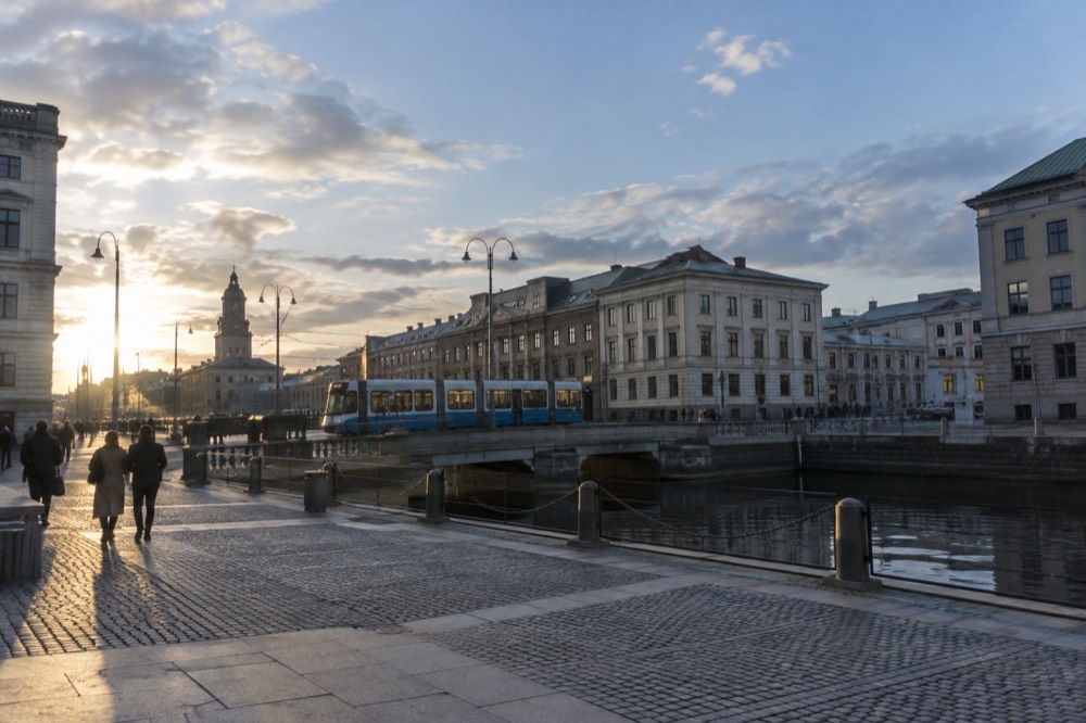 A Gothenburg tram passing brick buildings near the city canal