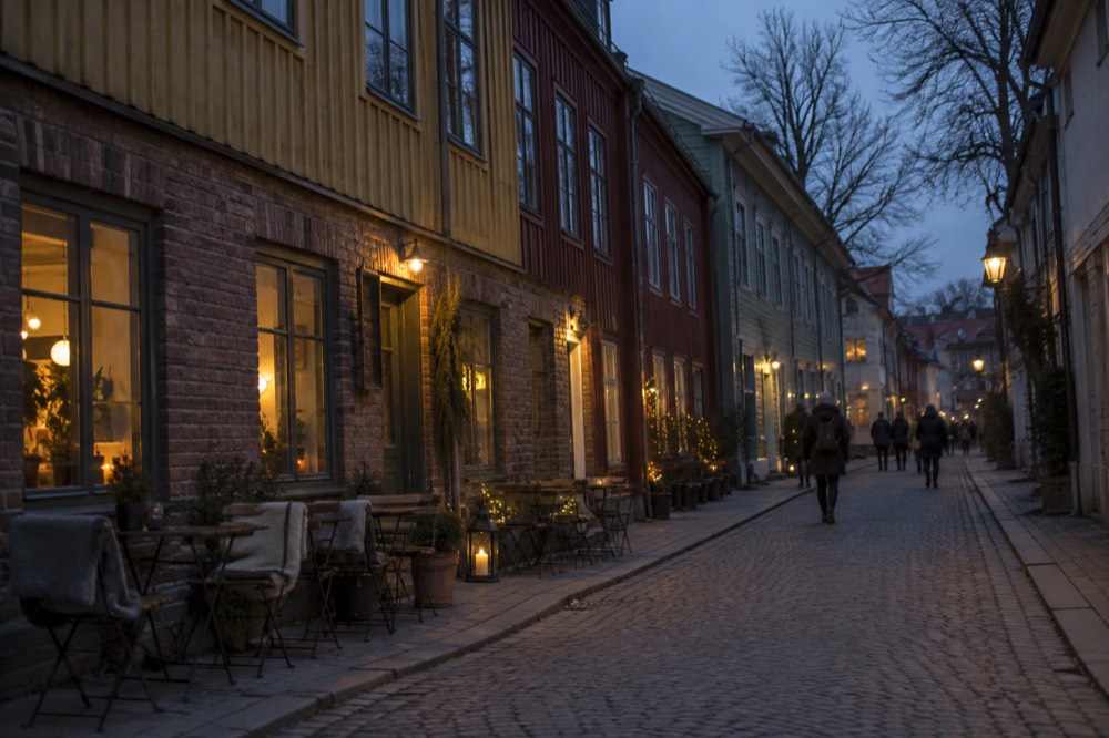 Street lamps and lit shop windows in Gothenburg's Haga district on a dark December afternoon