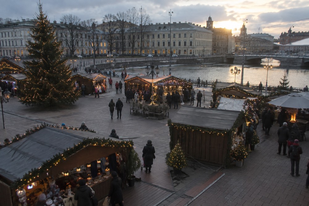 Festively lit Christmas market stalls in Gothenburg, Sweden, with strings of lights glowing against a winter evening