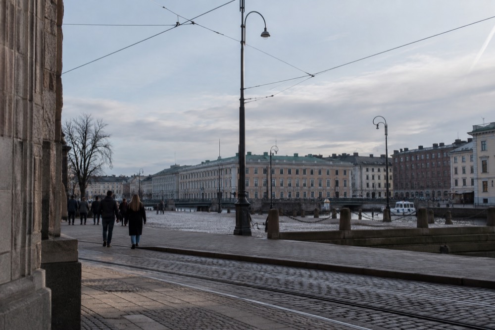 A quiet granite street in central Gothenburg with red brick buildings and tram tracks under grey light
