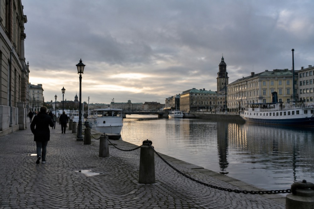 Golden evening light on the Göta älv river with boats and city buildings reflecting in the water