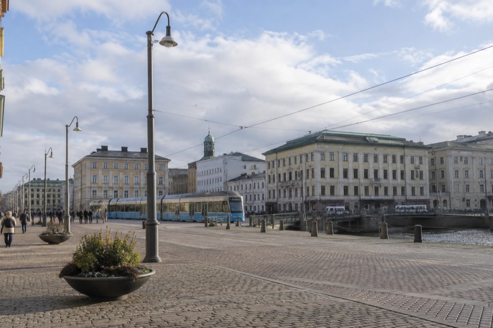 A blue Gothenburg tram crossing a central square near the old moat