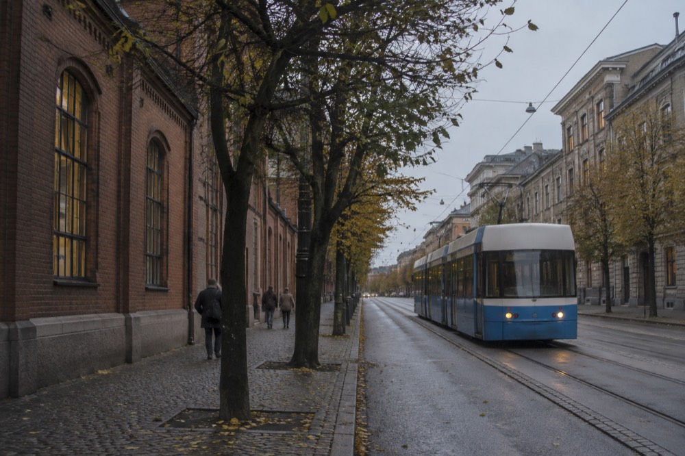 A Gothenburg tram passing along a city street with stone buildings on either side