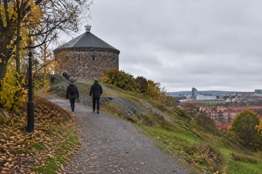 Gravel path climbing through autumn woodland toward the fort