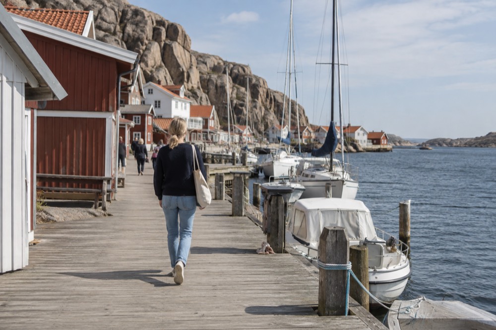 Steep granite cliff rising directly above a small harbour village