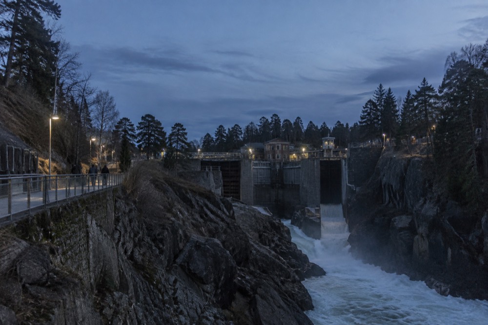 Water rushing through a narrow rocky gorge below a footbridge in a Swedish town