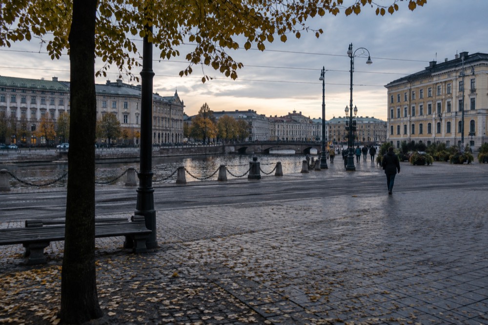 Autumn morning with low sun over a Gothenburg canal, leaves turning colour along the water