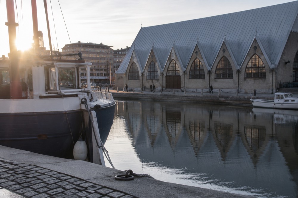 A Gothenburg canal with stone quays and moored boats near the market hall