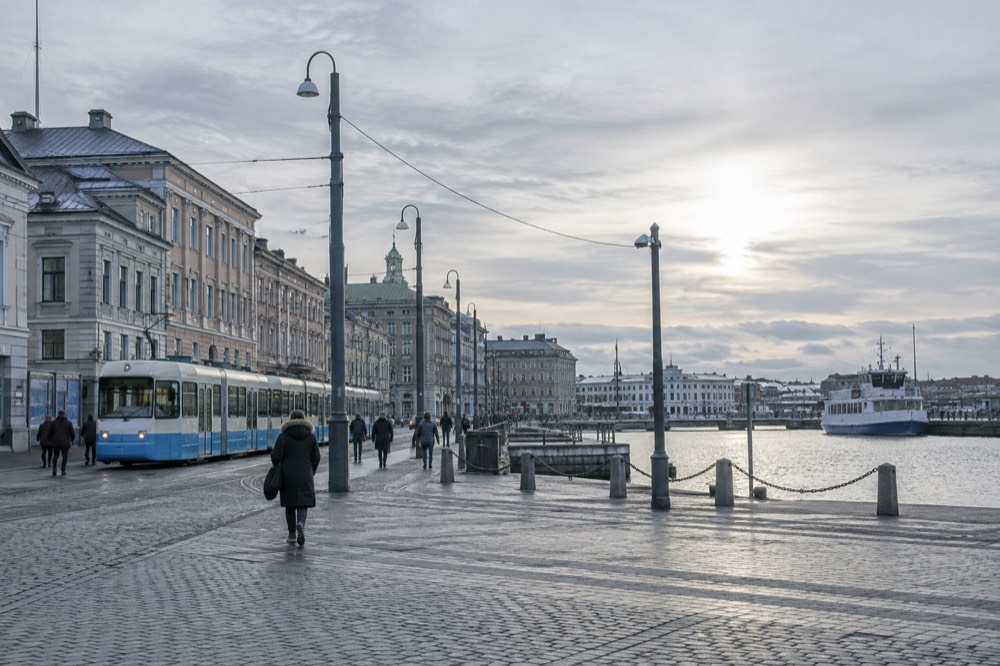 A Gothenburg tram passing along a riverside street near the ferry terminal