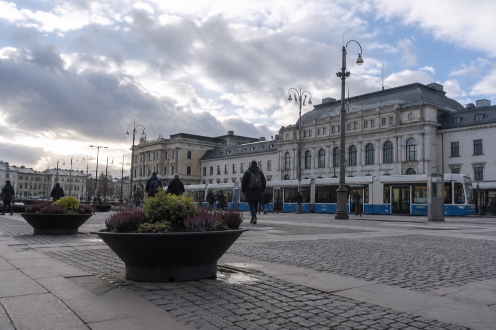 Trams passing in front of the stone facade of Gothenburg Central Station