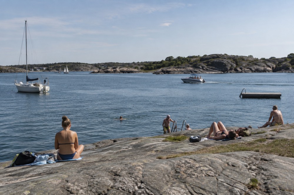 Swimmers on smooth granite rocks by the sea at a Gothenburg archipelago island