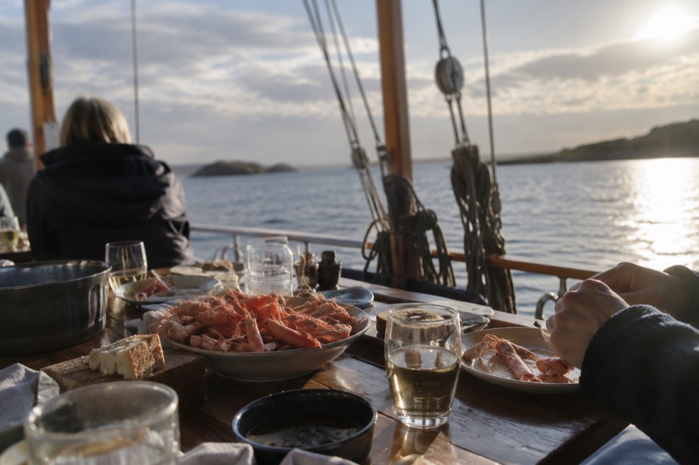 A sailing boat with passengers eating a shrimp meal in the Gothenburg archipelago