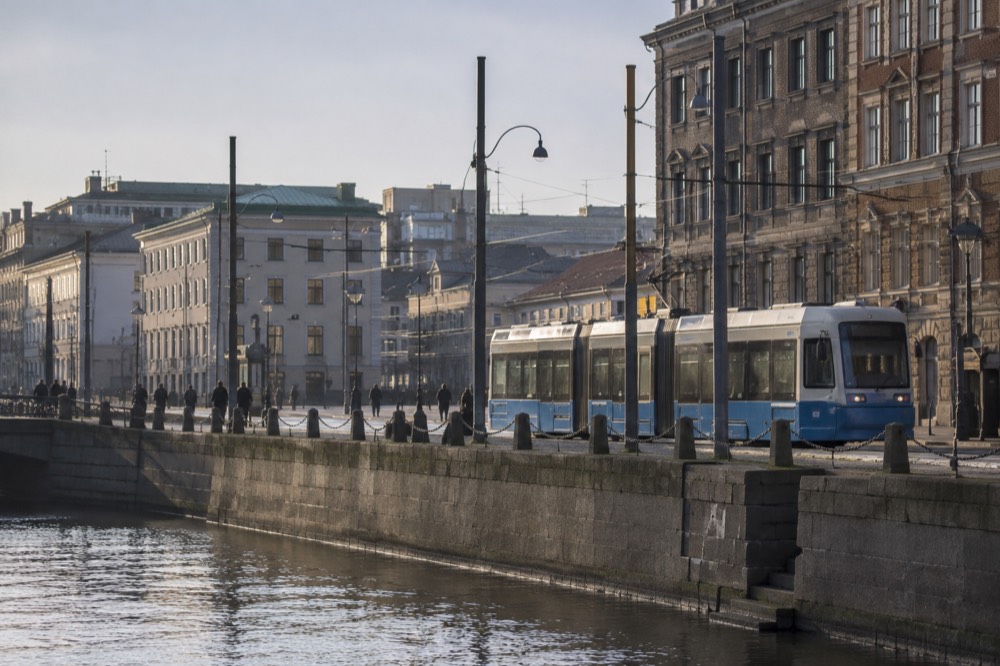 Gothenburg tram on a city street with brick buildings behind it