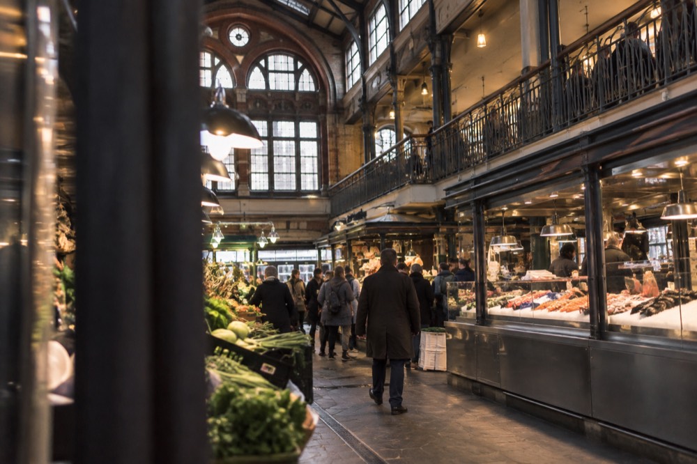 The ornate brick and glass facade of Stora Saluhallen market hall on Kungstorget in Gothenburg on a bright morning