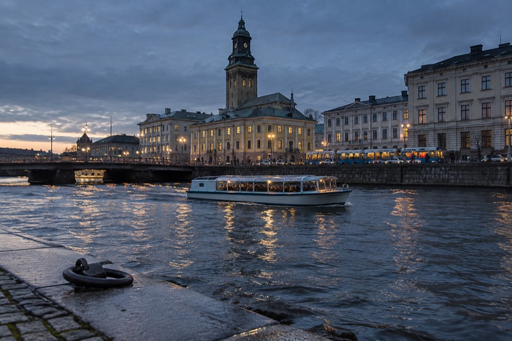An amphibious sightseeing boat cruising on the Göta älv river with the city skyline behind