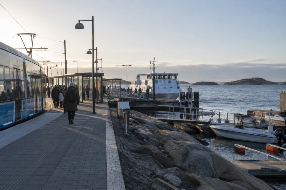 Saltholmen ferry terminal in Gothenburg with a tram at the stop and a white archipelago boat at the pier