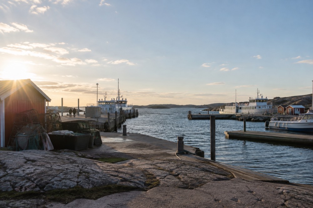 Small wooden fishing sheds and drying nets near a quiet island harbour