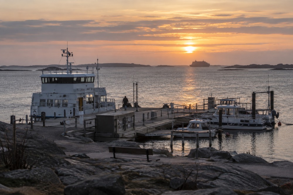 Low golden evening light over the archipelago sea with a ferry silhouette on the horizon