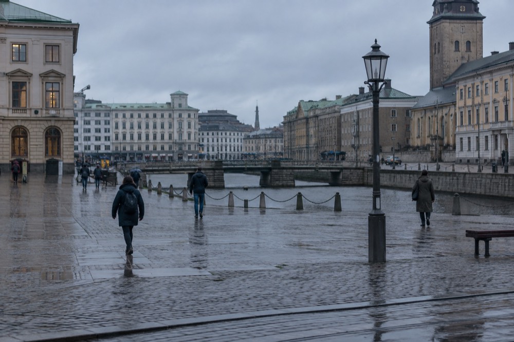 Rain-wet cobblestone street in Gothenburg old town with reflections in puddles