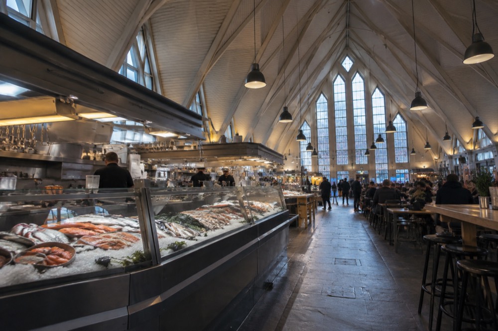 Fish market hall interior with counters and diners